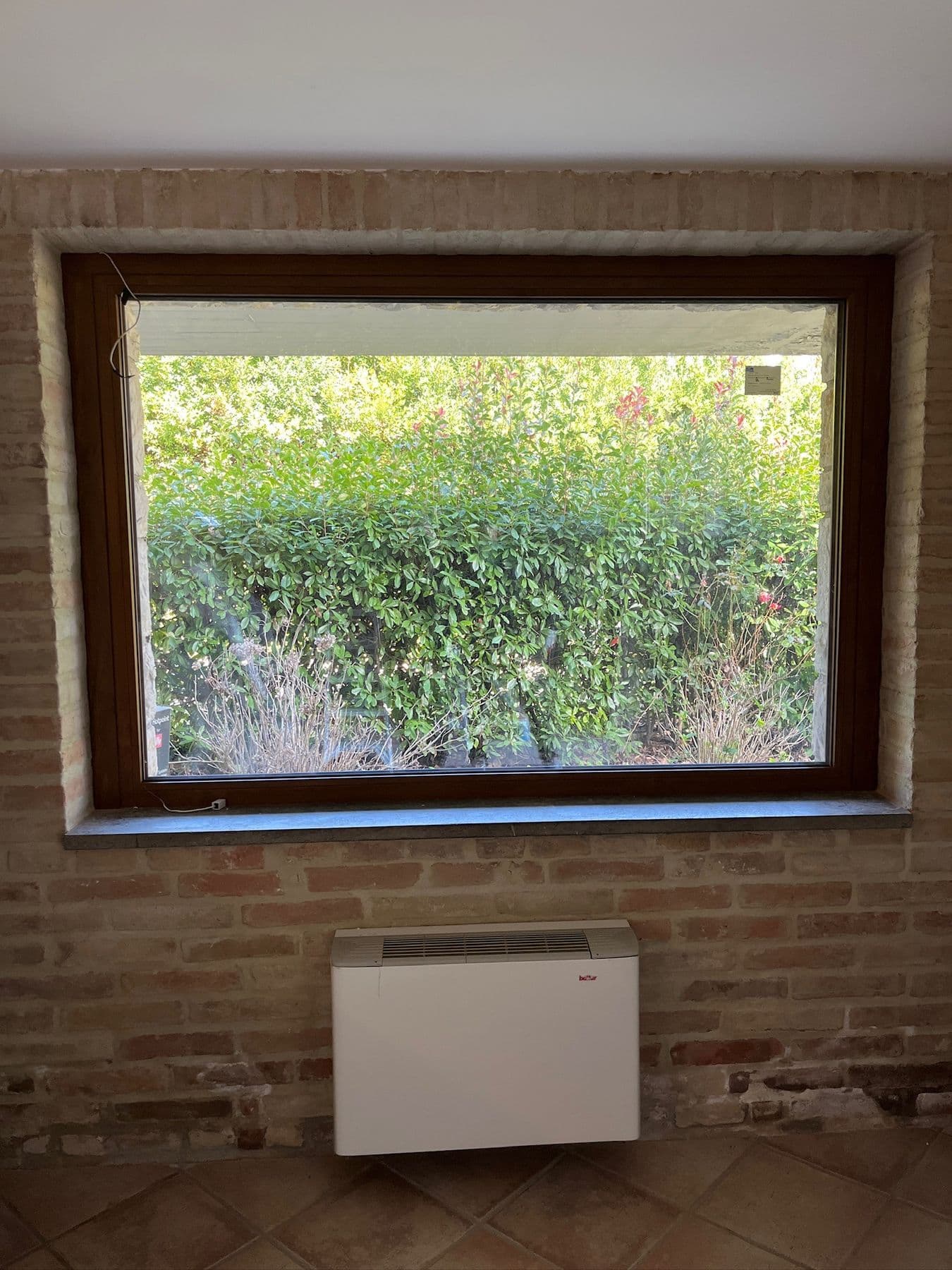 Finestra fissa in legno su parete in mattoni