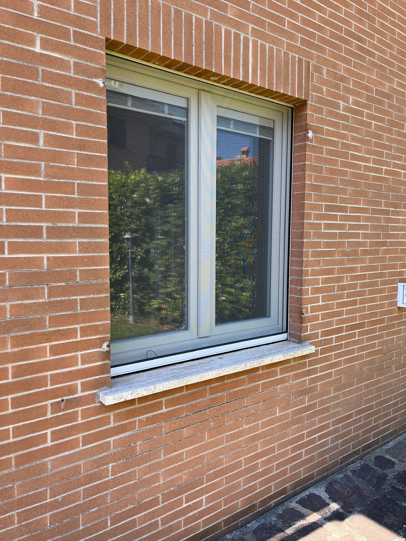 Finestra in PVC su facciata in mattoni